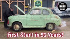Barn find Austin A30 with the bonnet up, a man leaning inside the engine bay and a puff of smoke from the exhaust