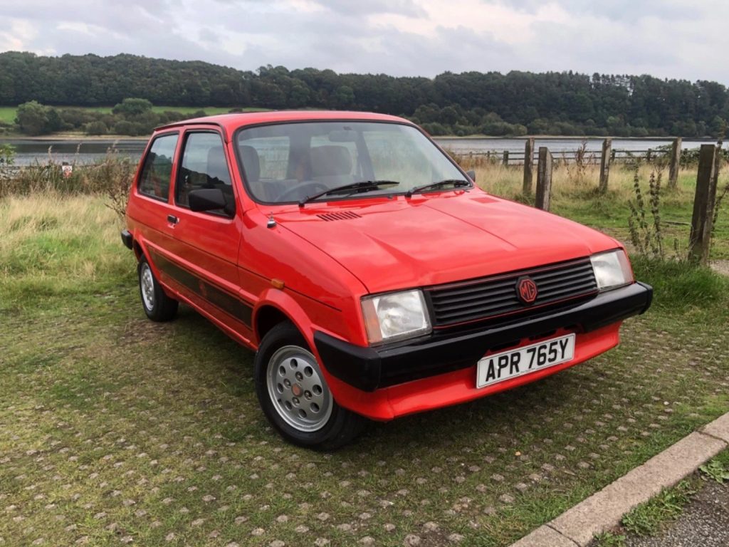 Early MG Metro Mk1 in red parked outdoors showing front three quarter view